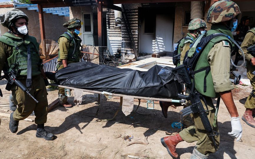 Israeli soldiers carrying a body in the Kfar Aza Kibbutz