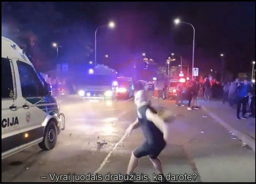 Artur Tochilov, a supporter of Paleckis, throws stones at police officers at a rally
