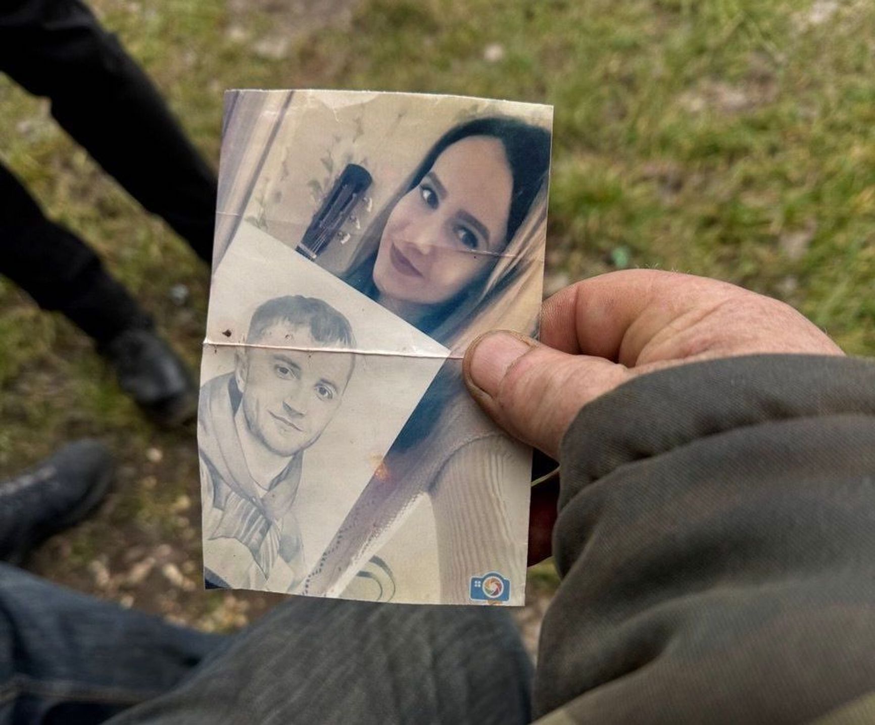 Anatolii Kulichenko shows a photograph of his murdered son Yevhen and his fiancée.