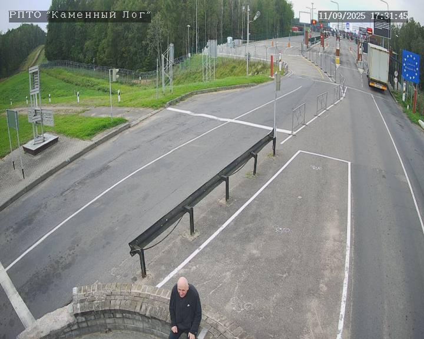 Mikola Statkevich in the "neutral zone" between the state borders of Belarus and Lithuania. The entry point to the latter, marked by a sign with an EU flag, can be seen in the background.
